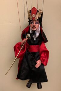 Jafar marionette dressed in red and black fine clothing and holding a sword
