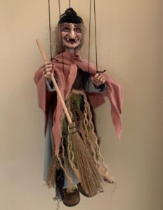 Old Witch marionette holding broom and wearing raggy clothes