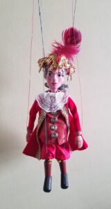 Prince Philip Marionette dressed in red and white royal clothing and wearing a red and gold hat